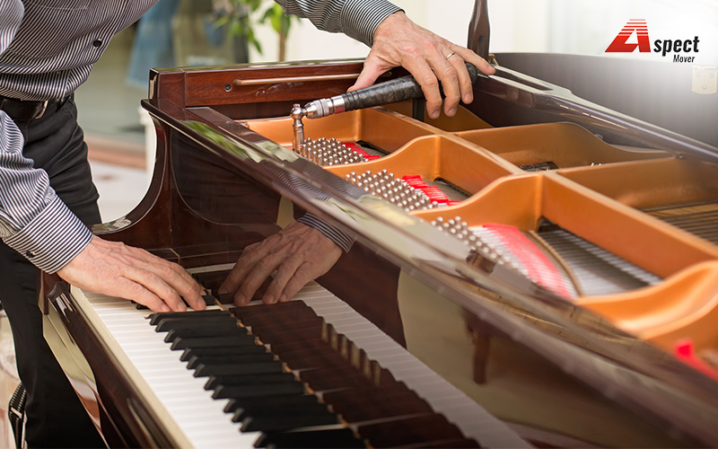 man dismantling an upright piano