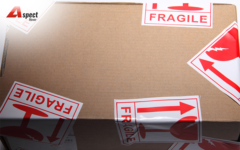 A cardboard box with multiple fragile labels pasted on it